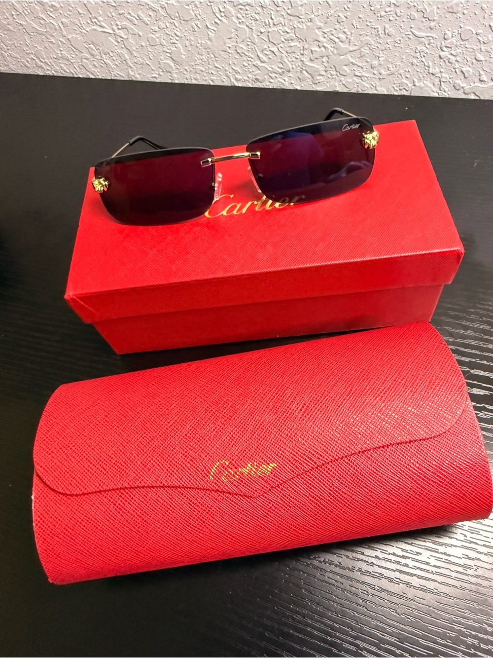 Cartier Rimless Sunglasses with Dark Lenses and Gold Details.